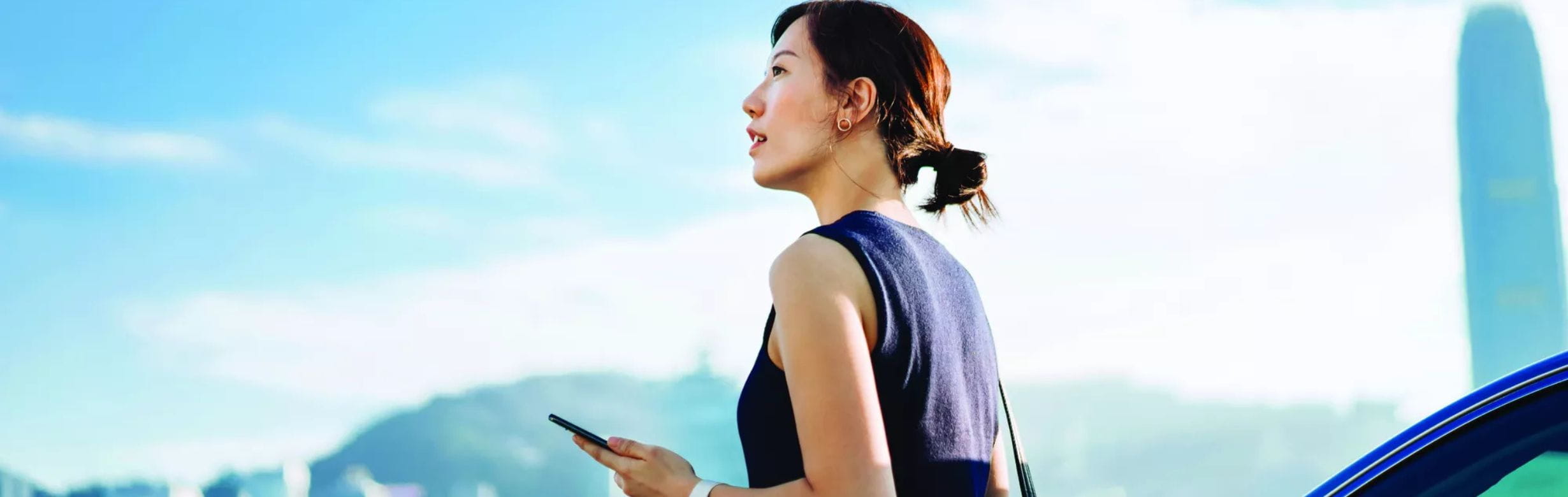 Woman with phone next to car